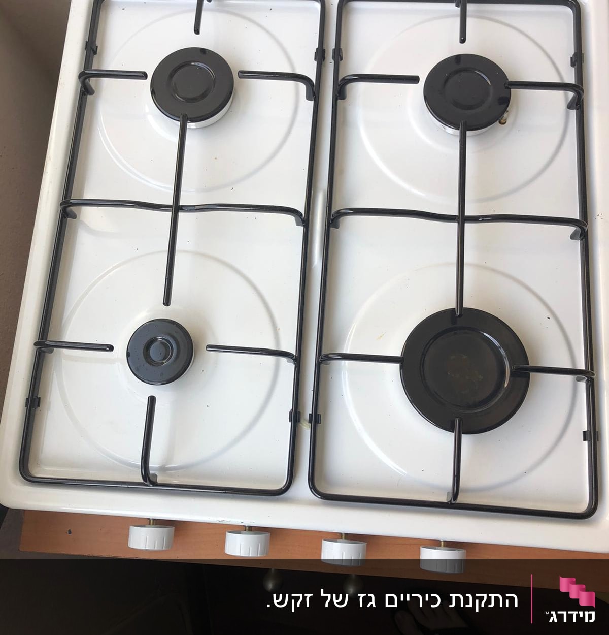כיריים גז לבנים עם ארבעה מבערים וכפתורי שליטה